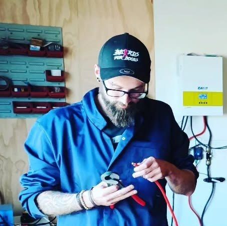 Een deelnemer werkt met een kabel en gereedschap tijdens een workshop thuisbatterij bouwen.